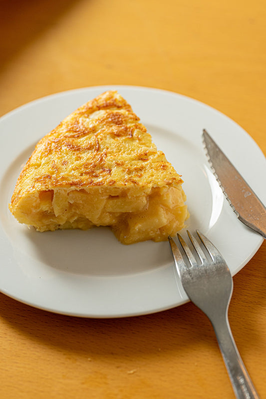 A slice of Spanish tortilla (tortilla española) showing the potato layers